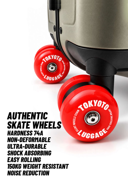 Close-up of a suitcase wheel area showing two bright red Tokyo Luggage skate wheels with white printed branding, alongside marketing text describing the wheels' features.
