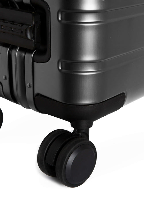 Close-up of a black suitcase wheel on a white background