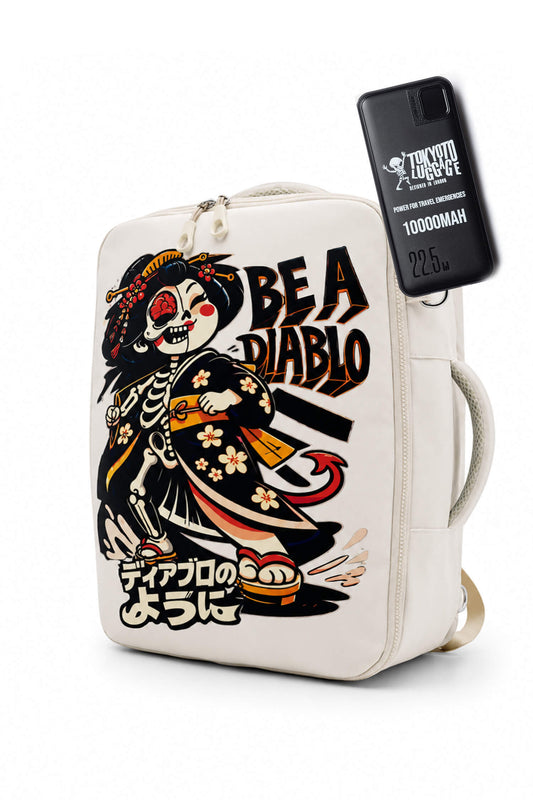 An off-white canvas backpack featuring a graphic illustration of a skeleton in a kimono with the text 'BE A DIABLO' and Japanese text. A black phone case with 'TRICK OR TREAT' branding is attached to the side zipper.